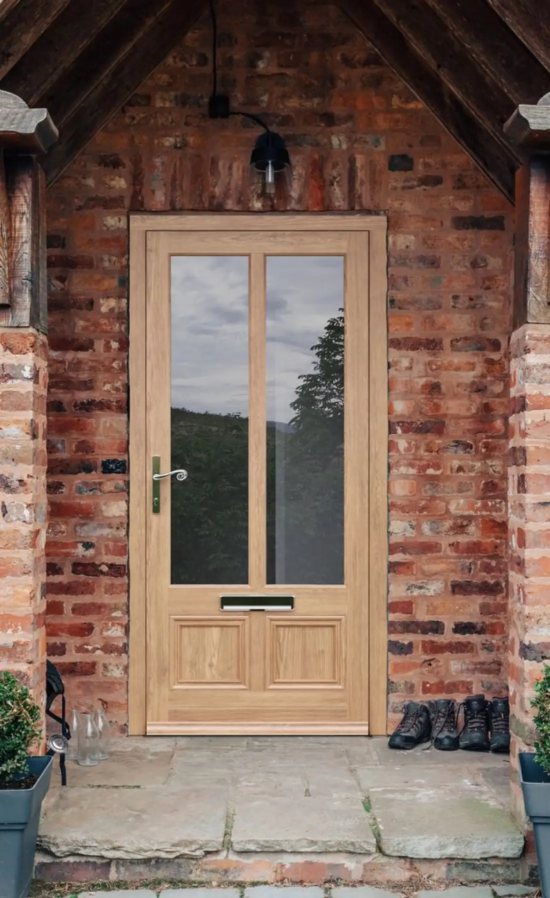 Oak timber entrance door with glazed panels in a brick porch